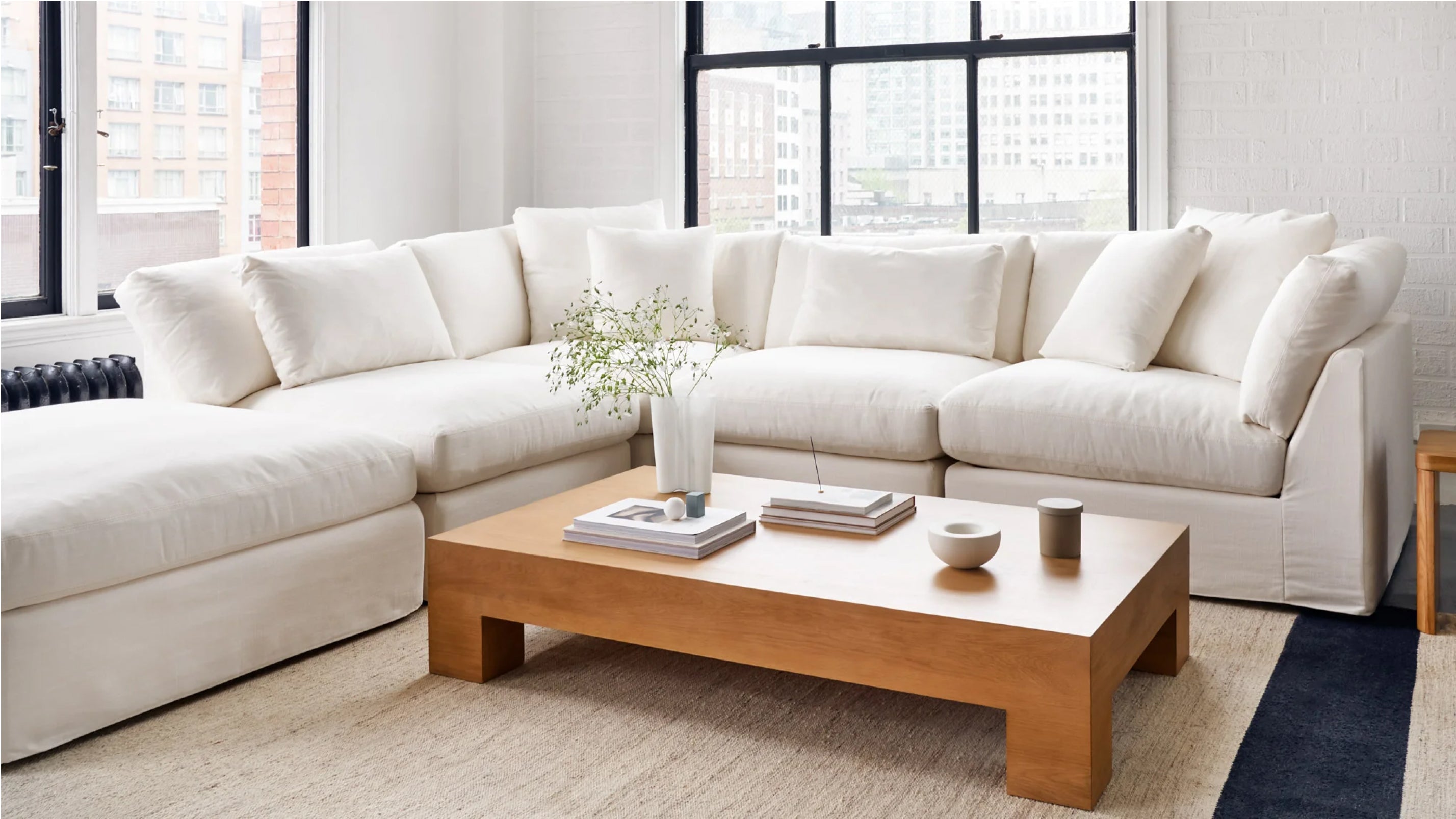 White sectional sofa in a living room with a wooden coffee table and decor items.